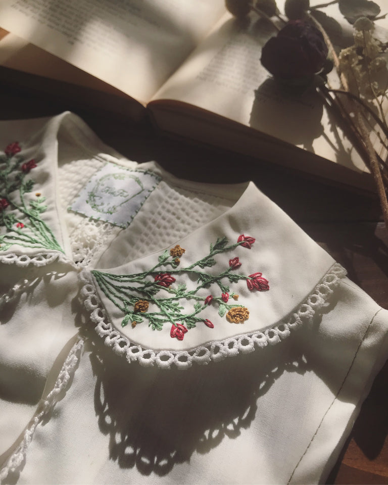 Hand embroidered peter pan collar made from an upcycled vintage blouse. Sustainable, handmade fashion at its finest! A whimsical meadow blooms from the center of this lace trimmed handmade piece. Compliments romantic, cottage core, & acadamia aesthetics. 